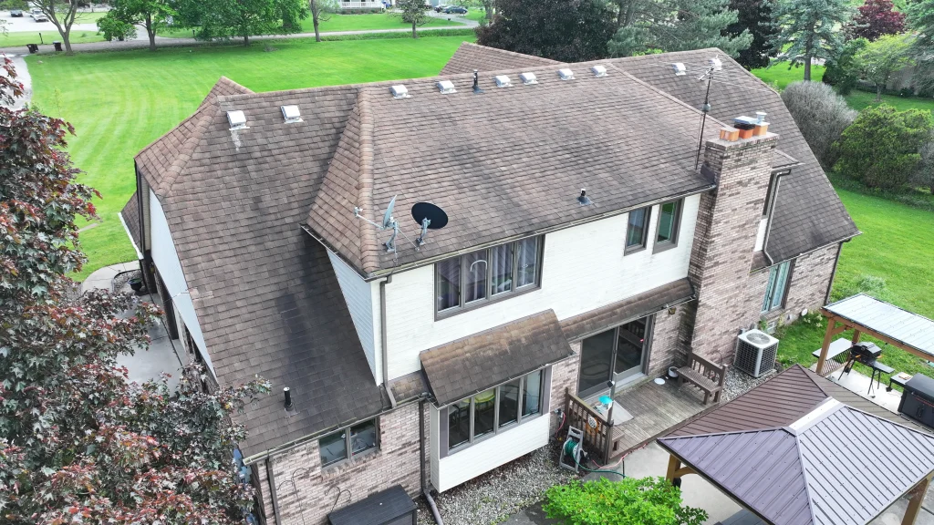 Aging residential asphalt shingle roof showing discoloration and wear